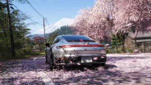 Sudraba krāsas Porsche sporta automašīna brauc pa ceļu zem ziedošiem sakuras kokiem, fonā redzams Fudzi kalns spēlē Forza Horizon 6