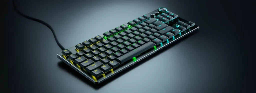 Melnā krāsā veidota Razer Huntsman V3 Pro Low-profile Tenkeyless spēļu klaviatūra ar zaļu un zilu taustiņu apgaismojumu uz tumša fona.