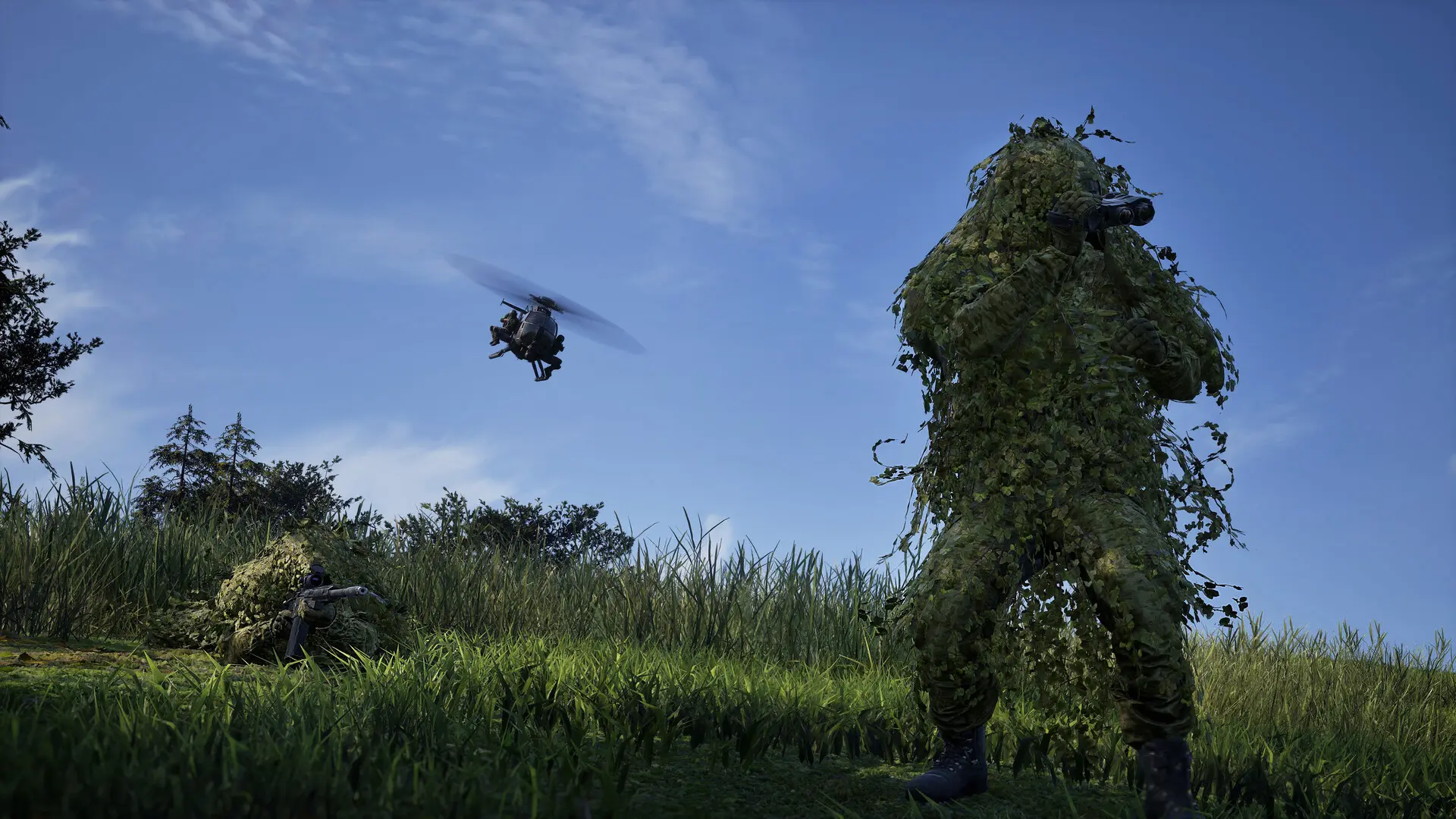 Divi spēlētāji pilnos lapu maskēšanās tērpos (Ghillie suits) pļavā; viens stāv ar binokli, otrs guļ zālē ar snaipera šauteni, fonā lido helikopters.